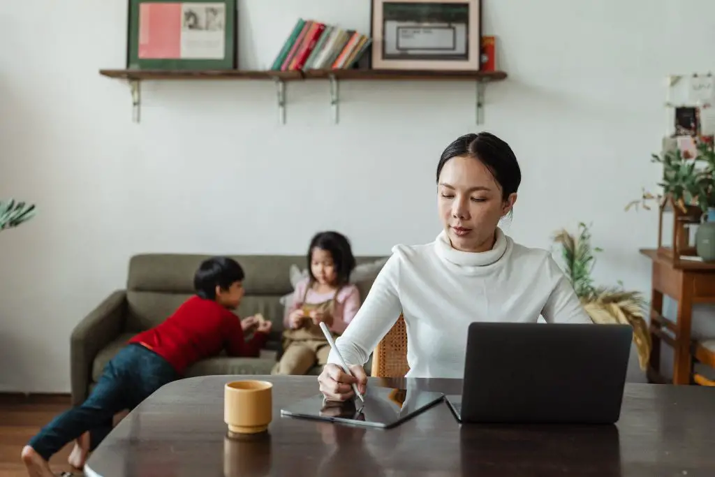 A mom working from home while her kids are in the background